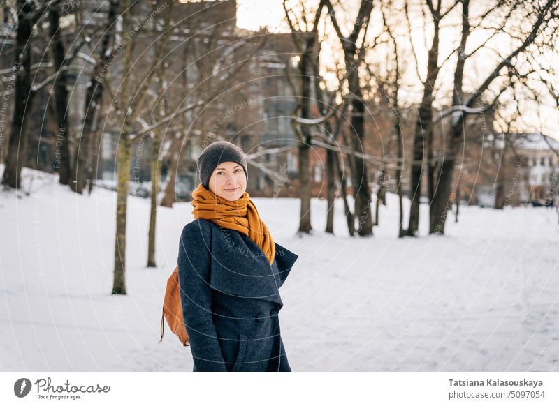 Eine Frau in warmer Winterkleidung schaut in die Kamera und lächelt im Winter Kleidung Lächeln kalt Schnee Fröhlichkeit Glück Freude Menschen Person Erwachsener