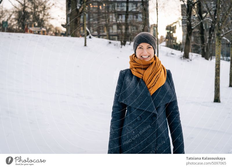 Eine junge Frau in Winterkleidung lächelt breit und schaut in die Kamera Lächeln Im Großen und Ganzen looki kalt Schnee Fröhlichkeit Glück Freude Menschen
