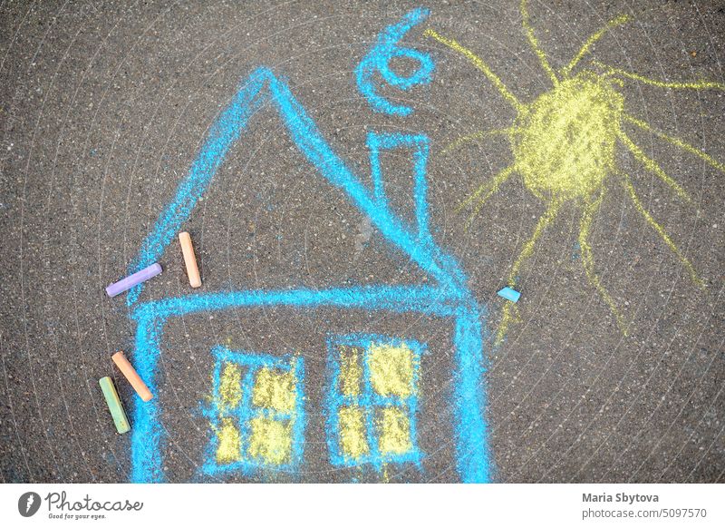 Kreidebild von Haus und Sonne auf Asphalt des Bürgersteigs. Kinder kreatives Bild auf grauem Hintergrund der Straße. zeichnen Farbe Frieden Welt heimwärts Kunst