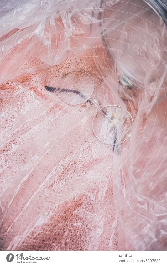 Vertikaler Hintergrund in rosa Tönen mit einer Brille und einem Spiegel über einem strukturierten Tuch flache Verlegung Textur vertikal Kunststoff altehrwürdig