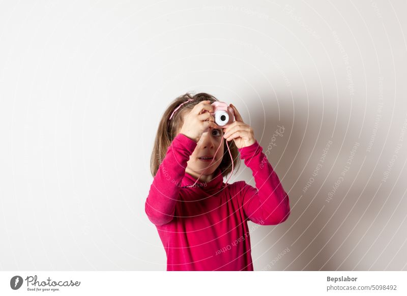 Kleines Mädchen, das ein Bild mit einer Spielzeug-Fotokamera aufnimmt Kind Menschen Fotograf Fundstück Genuss Linse Lebensstile Hobby Fotografie Gesicht Frau