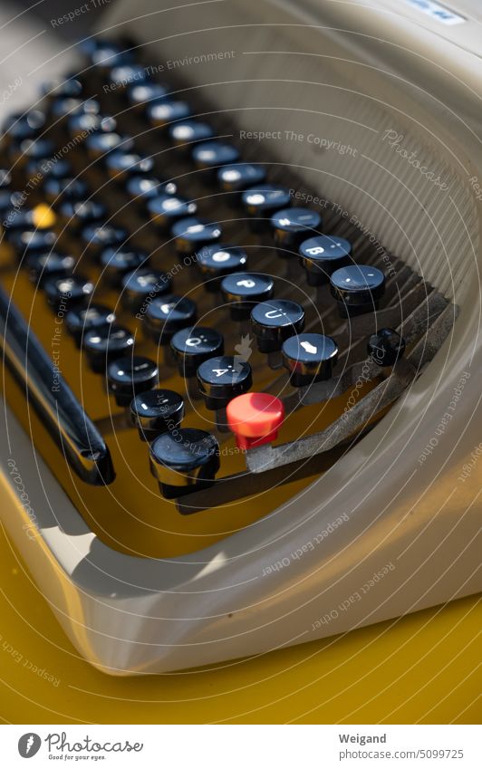 Detailaufnahme einer alten grauen Schreibmaschine auf einem gelben Tisch mit Fokus auf den Tasten Typewriter tippen schreiben Text texten Autor Kreativität