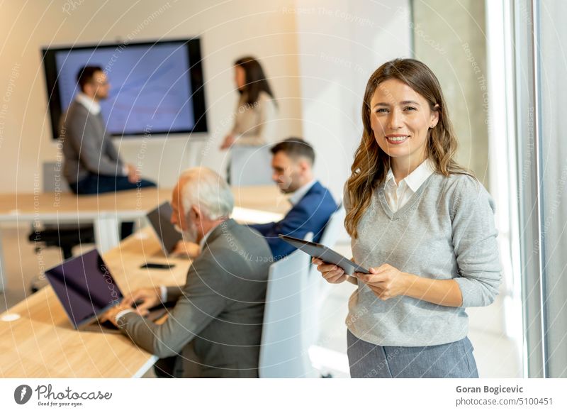Junge Geschäftsfrau im Büro eines Start-ups mit digitalem Tablet vor ihren Kollegen als Teamleiterin Erwachsener attraktiv schön Schönheit Business