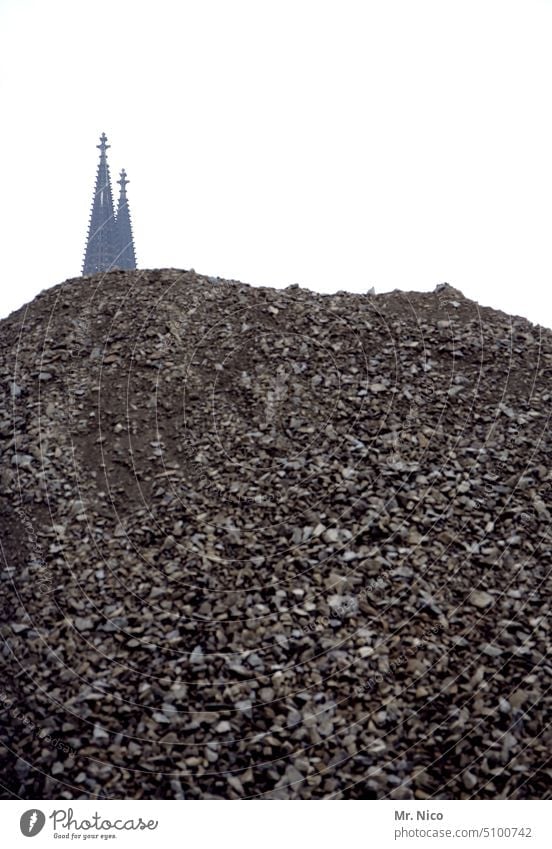 verschleiert I und doch erkannt aufgehäuft Hügel Erde aufgeschüttet Erdarbeiten Kirchturmspitze Domspitzen Kölner Dom grau trist verborgen verdeckt Baustelle