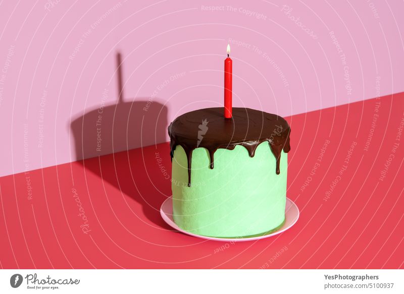 Geburtstagskuchen mit einer brennenden Kerze. Hausgemachter Kuchen mit Pfefferminz und Schokolade. Jahrestag Hintergrund Transparente schwarz Buttercreme Feier