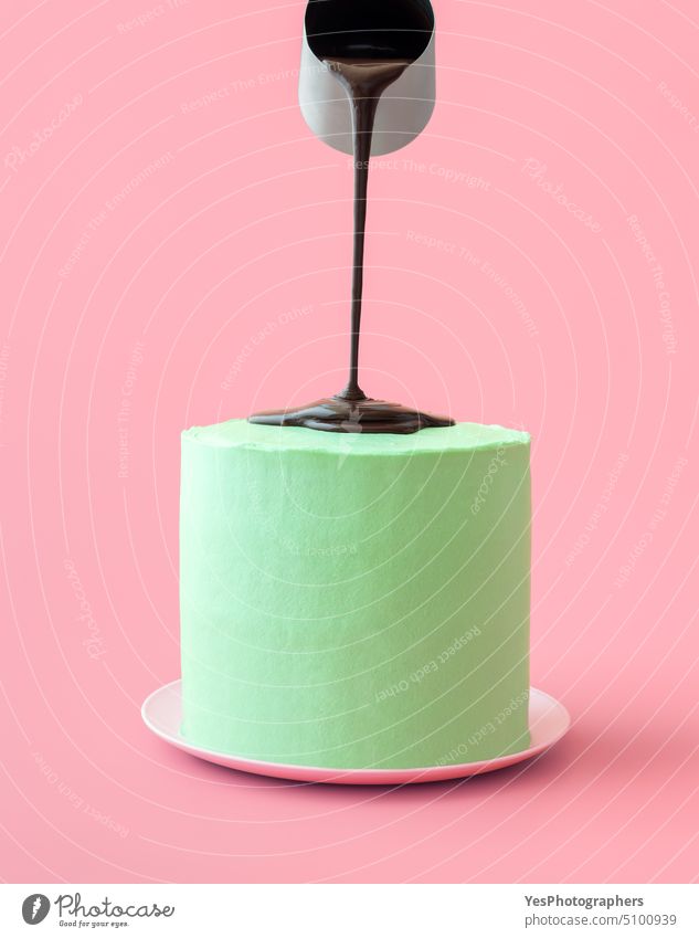 Gießen geschmolzener Schokolade über Pfefferminzkuchen, isoliert auf einem rosa Hintergrund Aroma Transparente Geburtstag schwarz Buttercreme Kuchen Feier