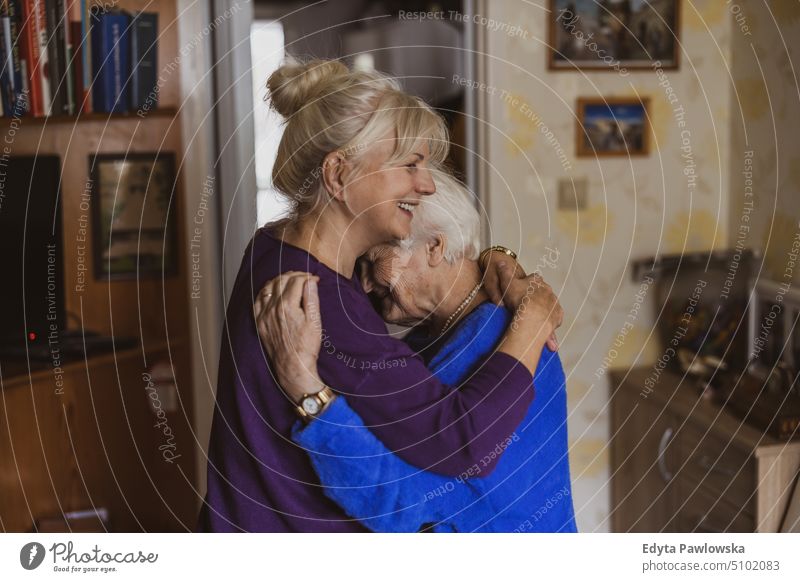 Frau, die ihre ältere Mutter umarmt Lächeln Glück genießend positiv Freude Menschen Senior reif heimwärts Haus alt Alterung häusliches Leben Großmutter
