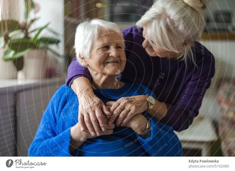 Frau, die ihre ältere Mutter umarmt Lächeln Glück genießend positiv Freude Menschen Senior reif heimwärts Haus alt Alterung häusliches Leben Großmutter