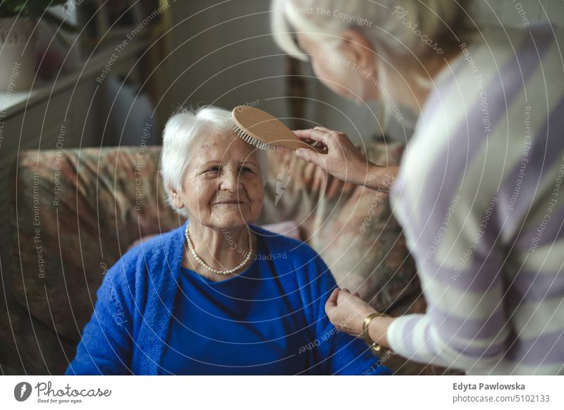 Frau kämmt die Haare ihrer älteren Mutter Lächeln Glück genießend positiv Freude Menschen Senior reif heimwärts Haus alt Alterung häusliches Leben Großmutter
