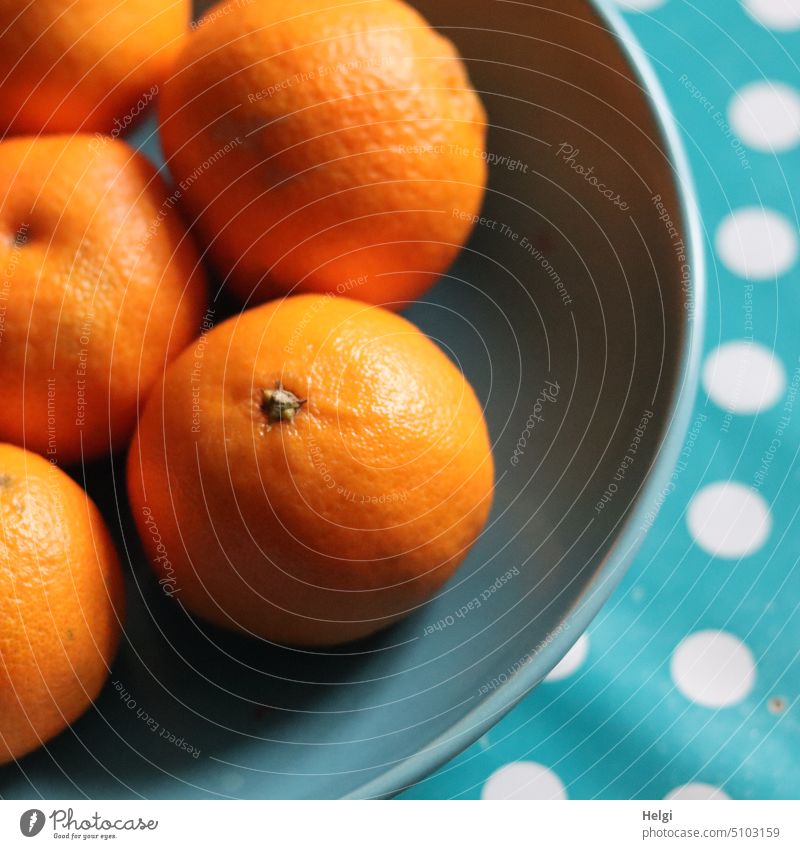 Clementinen liegen in einer türkisfarbenen Schale, darunter eine türkisfarbene Tischdecke mit weißen Punkten Obst Mandarine Orange Zitrusfrucht Frucht Vitamine