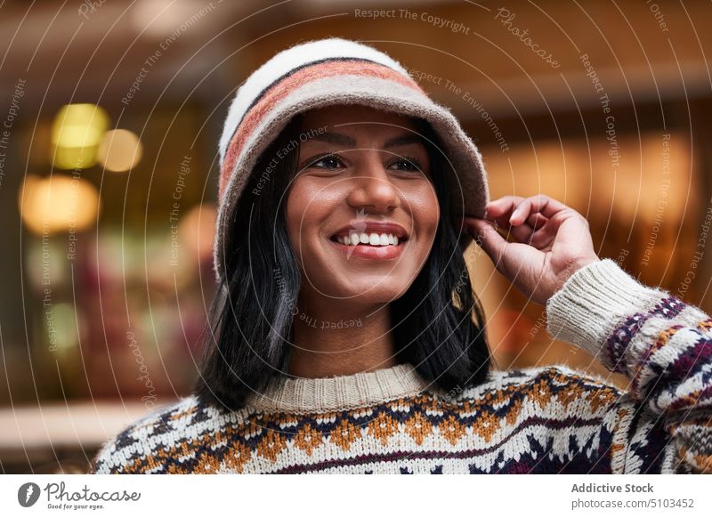 Stilvolle schwarze Frau auf der Straße Lächeln Glück Vorschein Outfit Porträt Hut Pullover jung ethnisch Strickwaren froh lässig Optimist Persönlichkeit