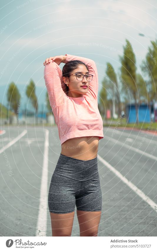 Schlanke Sportlerin streckt die Arme vor dem Laufen Frau Athlet Dehnung Läufer Laufbahn Training Aktivität passen sportlich schlank jung Körper Energie bereit