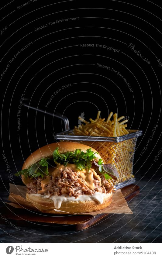 Leckerer Burger mit Pommes frites auf dem Tisch dienen Französisch Fries geschmackvoll Junk Food Fastfood Mahlzeit lecker kulinarisch Brioche Brot ungesund