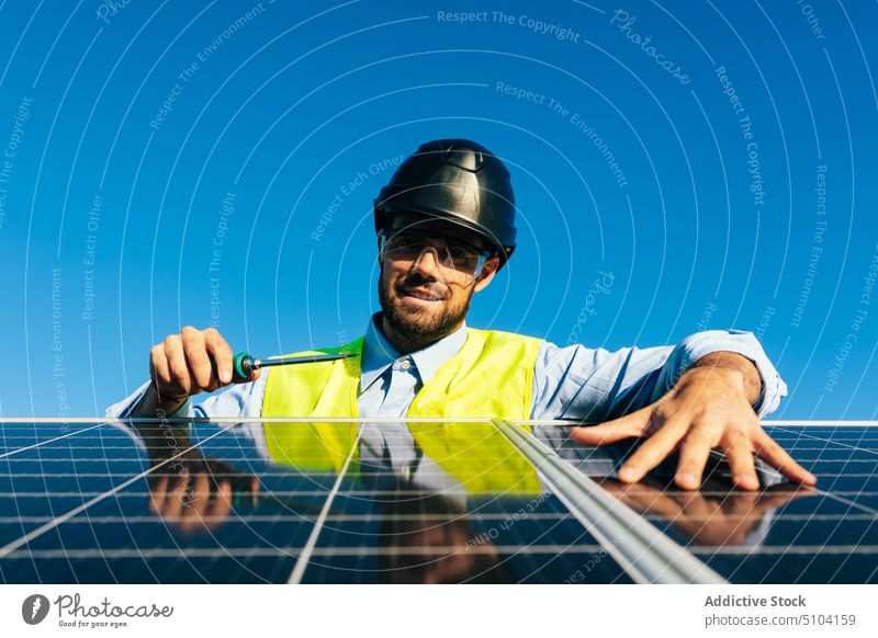 Solarmodul-Installateur bei der Arbeit Mann Techniker Photovoltaik Sonnenkollektor installieren Erneuerung Schraubendreher nachhaltig alternativ
