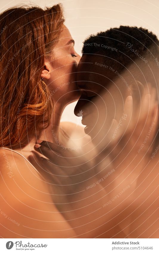 Freundin küsst ethnischen Freund auf die Stirn Paar Kuss Liebe Partnerschaft Umarmen Augen geschlossen Umarmung sanft Angebot romantisch Atelier Bonden