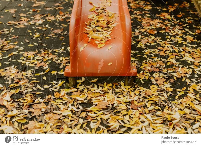 Rote Rutsche mit gelben Blättern rot Herbst Herbstlaub fallen Herbststimmung Laubwerk Herbstfärbung herbstlich Herbstbeginn Blatt Natur Park Spielplatz