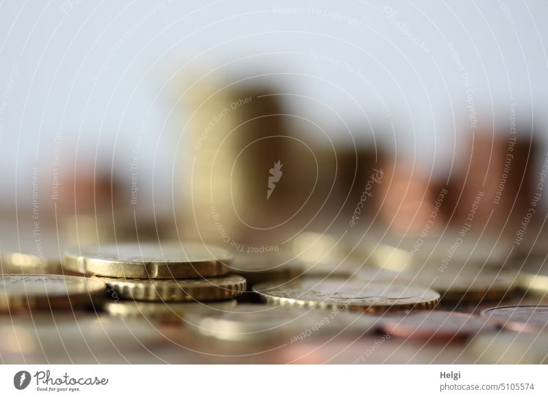 viele Geldmünzen liegen auf einem Tisch, im Hintergrund unscharfe gestapelte Münzen Euro Euromünzen Eurocent Kleingeld Sparen bezahlen Sparsamkeit sparen