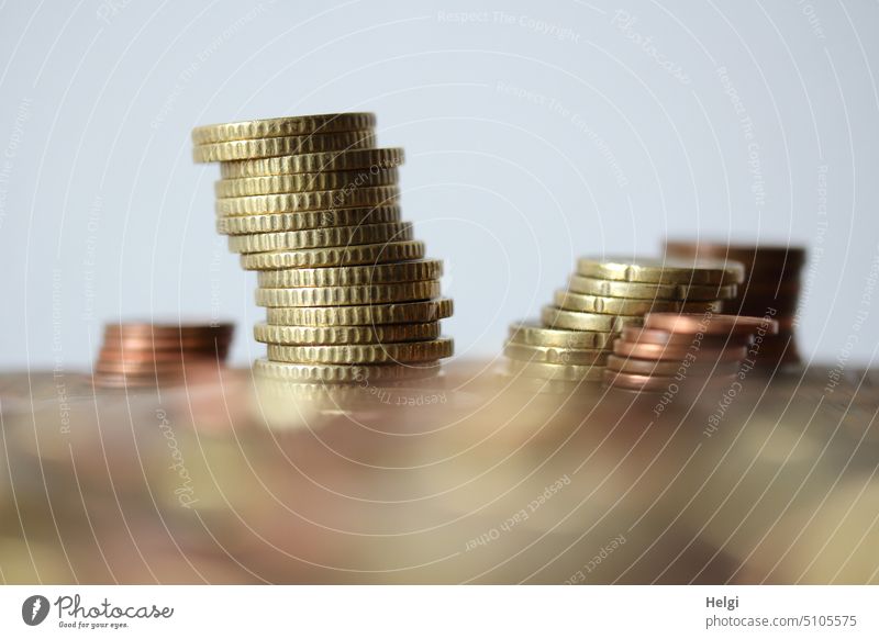 gestapelte Münzen auf einem Tisch, im Vordergrund unscharfes Kleingeld Geld Euro Euromünzen Eurocent Sparen bezahlen Geldmünzen viele Sparsamkeit sparen Bargeld