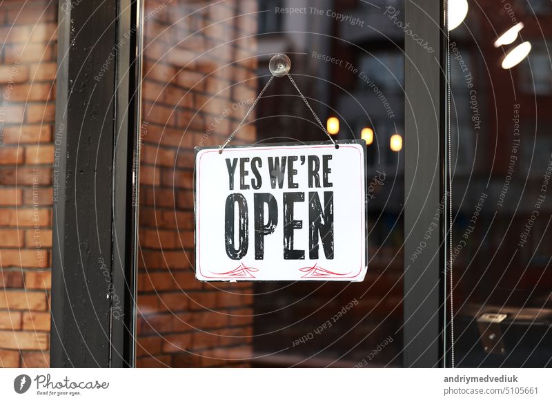 Aufschrift Ja, wir sind offen Metallschild mit schwarz-weißem Schild auf Glastür Geschäft, Café, Kosmetikladen, Friseur nach Coronavirus-Quarantäne. Geschäft wieder geöffnet