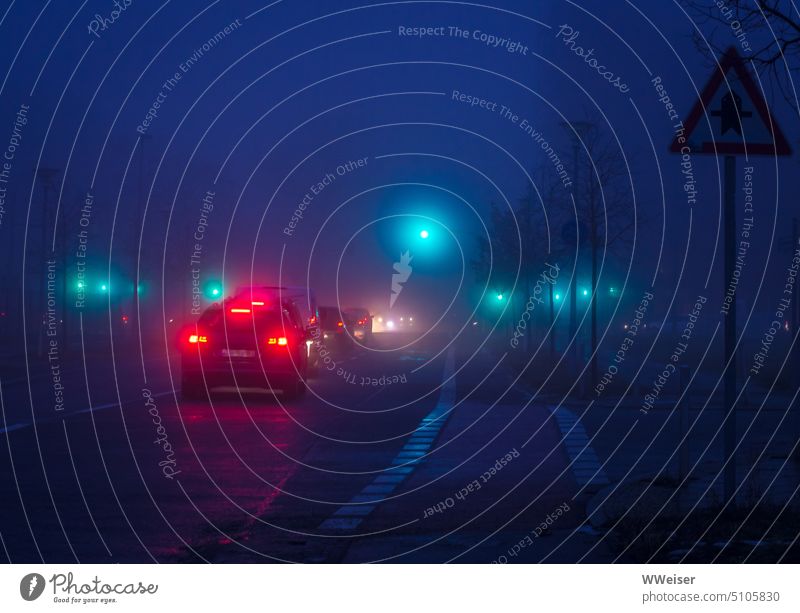 Ein nebeliger Abend im November, müde Arbeitnehmer fahren mit dem Auto nach Hause Straße Autos Berufsverkehr Verkehr Nebel neblig diesig undeutlich unklar