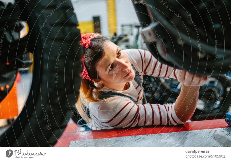 Mechanikerin überprüft Motorrad in der Fabrik Frau Arbeiter Überprüfung überblicken arbeiten Reparatur Porträt Garage Werkstatt konzentriert professionell