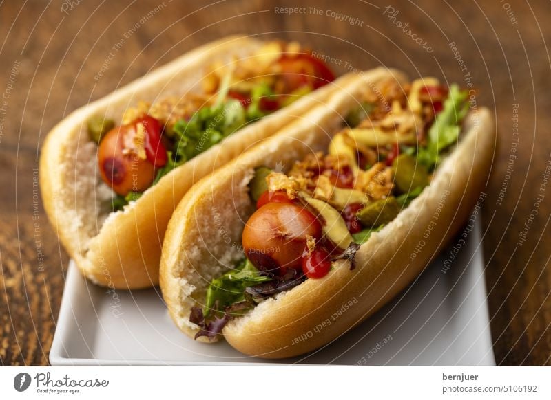 Zwei klassische Hotdogs im Brötchen Wiener Fast Food Junkfood Kalorien fett lecker Gourmet Tomate Bratwurst Frankfurter Weenie Hot-Dog Wieners gelb Ketchup