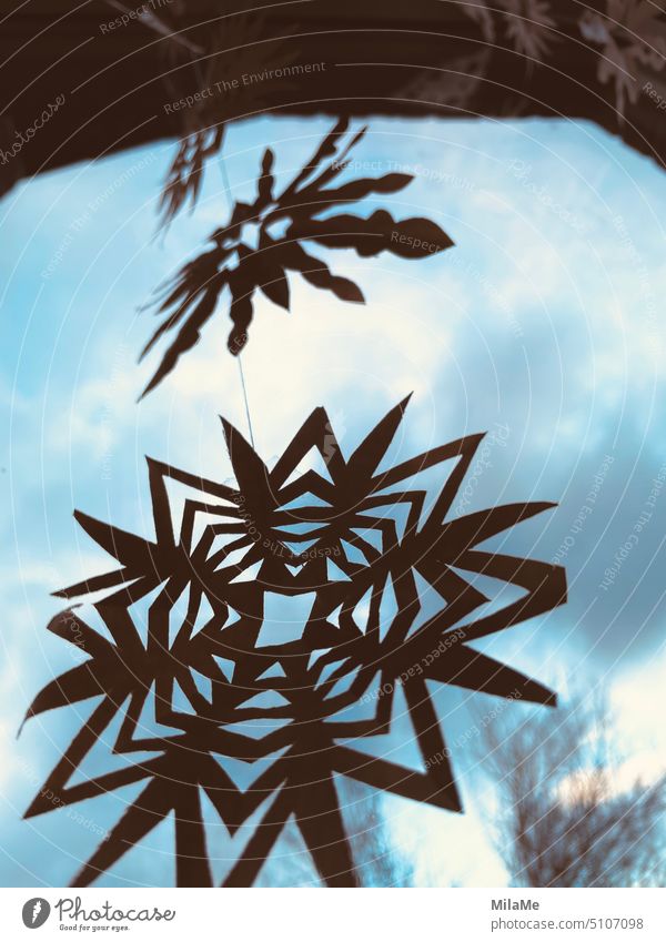 dekorative weihnachtliche Papiersterne hängen als Girlande am Fenster mit blauem Himmel im Hintergrund Basteln Dekoration & Verzierung Freizeit & Hobby