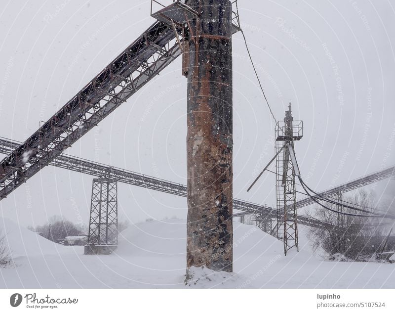 Förderbandstützen eines Kieswerks im Schnee eingeschneit Winter Bayern graubraun Quetschwerk Januar weiß diffus
