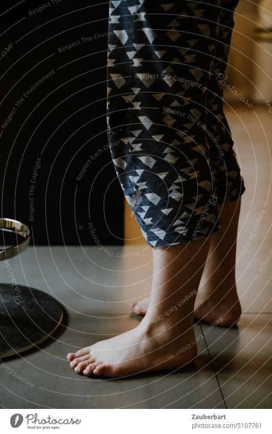 Füße, Beine und Unterschenkel eines Mädchens in Freizeit-Hose auf gefliestem Boden Zehen barfuß Schlafanzug gemütlich morgens stehen Licht Fuß Frau aufstehen