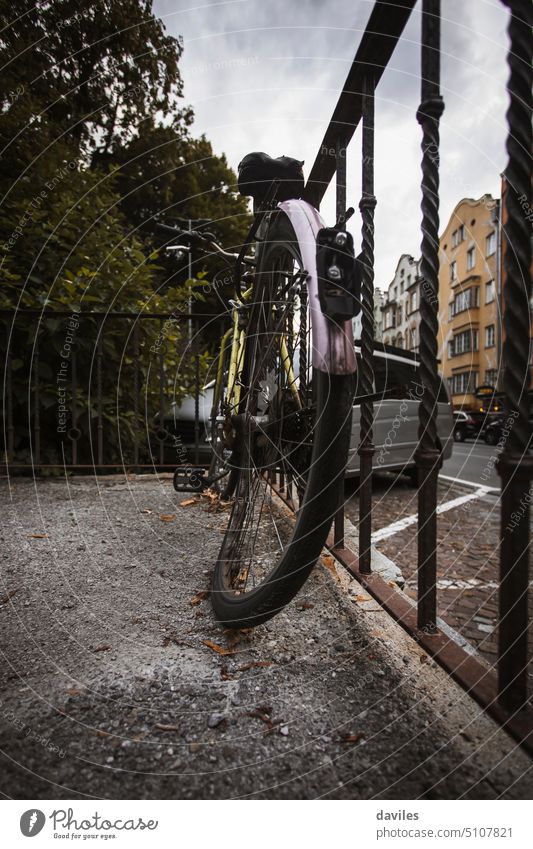 Verlassenes Fahrrad in einem Zaun, in der Stadt Innsbruck, Österreich. angewinkelt gebogenes Rad schwarz gebrochen Zyklus Beschädigte zerstört dreckig Europa