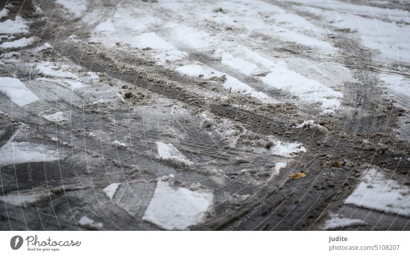 Spuren von Autoreifen im Schnee auf Asphalt abstrakt Hintergründe schwarz Schneesturm PKW Nahaufnahme kalt Konzepte Voraussetzung Kontrast Kurve Regie Frost