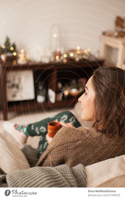 Schöne kaukasische Frau lächelnd in ihrem gemütlichen Haus Wohnung lehnt sich über die Couch. Lässiger Lebensstil weibliches Porträt. Millennial Leben. Expat-Leben. Erstellen komfortablen Raum um Sie herum.