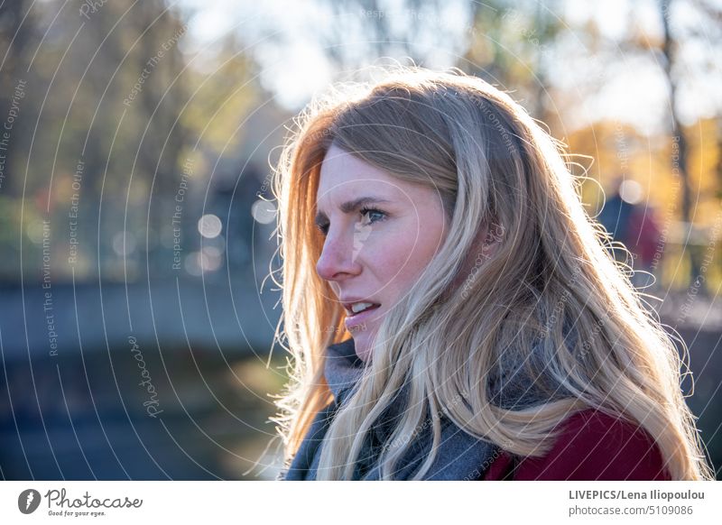 Seitenansicht Kopfschuss einer europäischen jungen blonden Frau Aktivität Herbst Hintergründe Körperteil Großstadt Stadtleben Bekleidung Mantel kalt