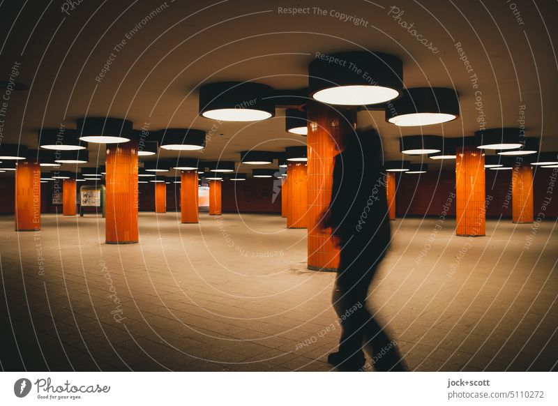 Unterführung mit Fußgänger in Orange aufgebaut Untergrund Architektur Säule retro Fliesen u. Kacheln Beleuchtung Strukturen & Formen Bewegungsunschärfe Schatten