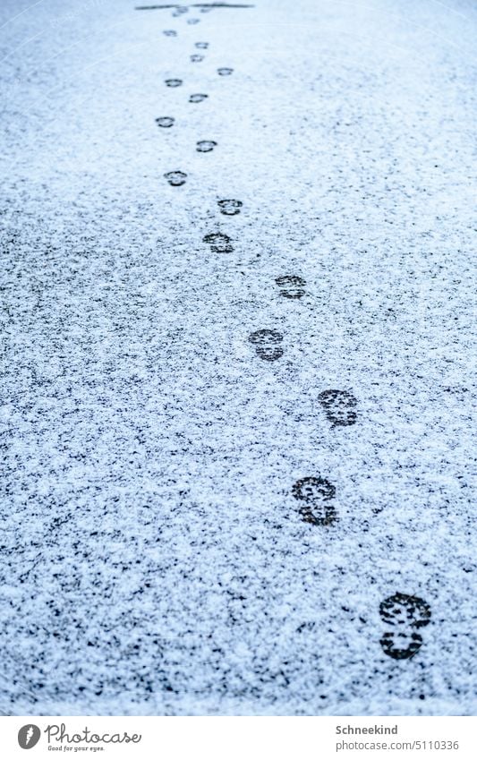 Fußabdrücke im Schnee fußabdruck Spuren Winter Schuhe Schuhsohle Wege & Pfade Kinder Füße auf dem Boden Fußweg weis hell kalt schneebedeckt Straße Einsam stille