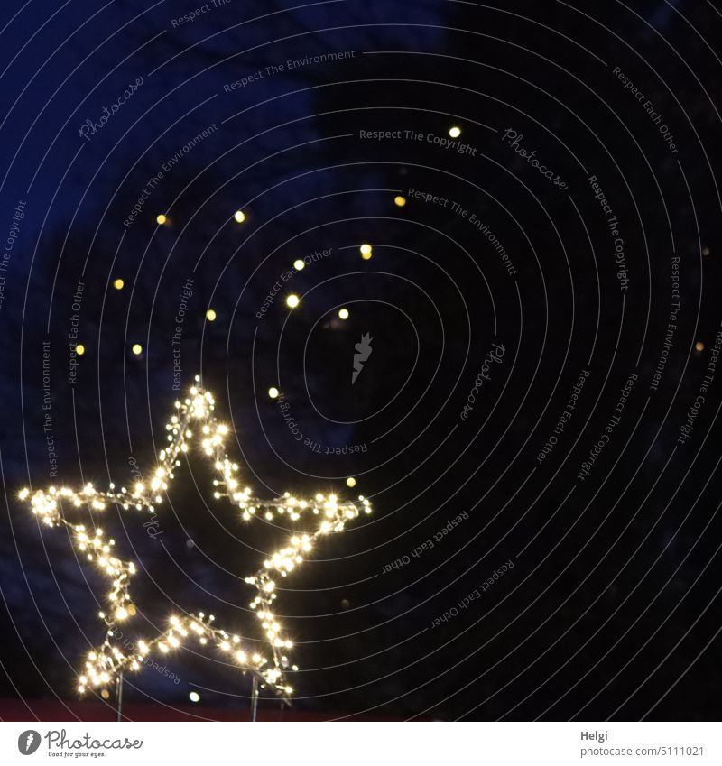 leuchtender Stern  mit kleinen Lichtpunkten im Hintergrund vor dunklem Himmel Stern (Symbol) Weihnachten Advent Weihnachtsdekoration Dekoration & Verzierung