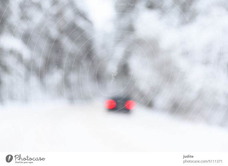 Unscharfe abstrakte schneebedeckte Bäume im Wald und rote Auto-Rücklichter auf der Straße Gasse Kunst Hintergrund Unschärfe verschwommen Bokeh hell Business PKW