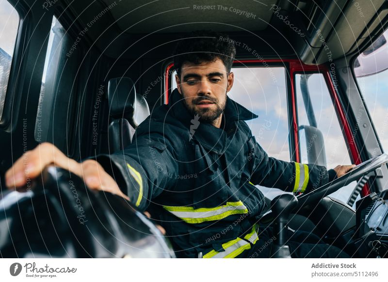 Spanischer Feuerwehrmann bereitet sich auf das Fahren eines Feuerwehrautos vor professionell Fahrer vorbereiten Arbeit Notfall Uniform behüten Schutzhelm