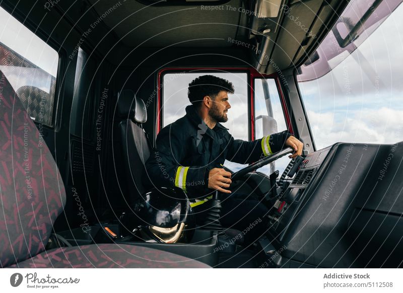Hispanischer Feuerwehrmann fährt Feuerwehrauto Laufwerk Lächeln Arbeit Notfall freundlich Uniform behüten Porträt männlich Erwachsener hispanisch ethnisch