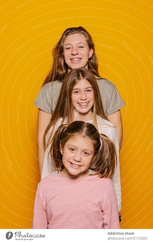 Fröhliche Schwestern schauen in die Kamera Glück heiter Zusammensein Lächeln Kind Freude positiv Mädchen hell aufgeregt farbenfroh lässig Optimist jung Spaß