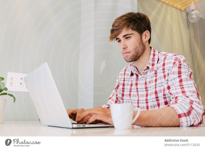 Junger Mann bei der Arbeit im Büro Erwachsener Business Geschäftsmann Computer selbstbewusst Tasse Unternehmer gutaussehend Hipster Job Laptop männlich modern