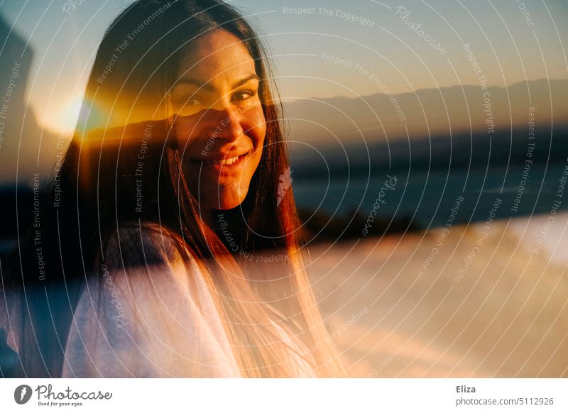 Doppelbelichtung einer lächelnden Frau mit einem Sonnenaufgang Optimismus Porträt dunkelhaarig strahlen Junge Frau Blick in die Kamera Ferne hübsch warm Wärme