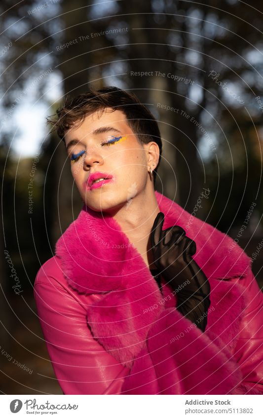Transsexueller Mann mit Make-up steht im Park mit geschlossenen Augen transsexuell Wald Augen geschlossen Tasthals lgbt androgyn Stil Herbst Homosexualität