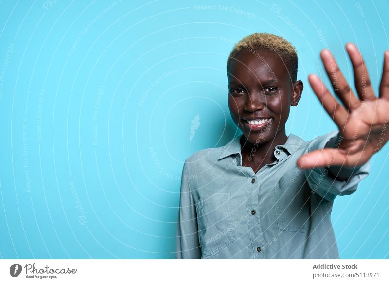 Junges afroamerikanisches Model streckt die Hand in die Kamera Frau sich[Akk] melden Lächeln Glück Stil Vorschein lässig blond Farbe hell jung schwarz