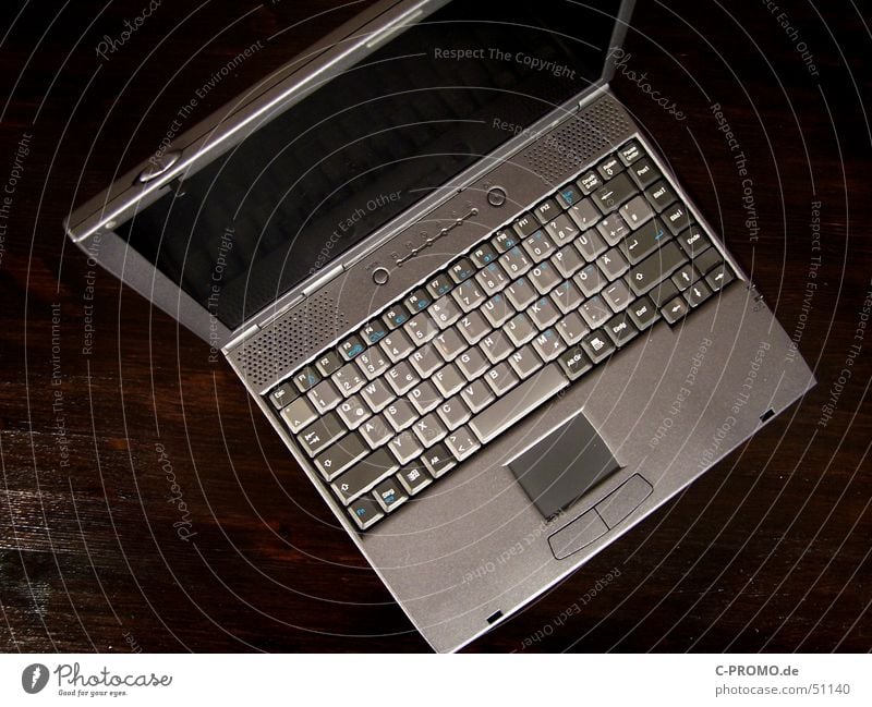 Grauer Laptop Touchpad Bildschirm flach Mobilität grau braun Tisch Vogelperspektive teuer Innenaufnahme Elektrisches Gerät Technik & Technologie Medien Tastatur