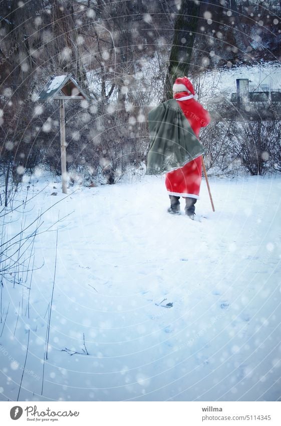 Der Weihnachtsmann stapft durch den verschneiten Winterwald Sack Schnee Weihnachten Geschenke winterlich Vogelhäuschen Santa Claus beschenken Gaben