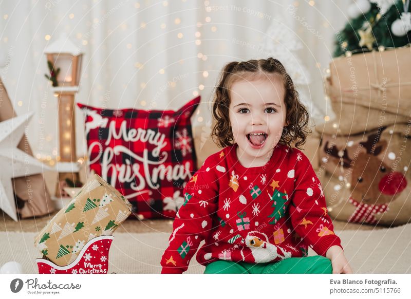 Süßes lächelndes kleines Mädchen zu Hause mit Geschenken zur Weihnachtszeit Kind Weihnachten heimwärts Glück heiter niedlich 2 Kinder Familie Dezember
