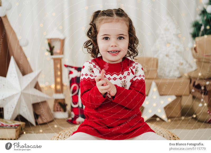 Lächelndes kleines Mädchen zu Hause zur Weihnachtszeit Kind Weihnachten heimwärts Geschenke Glück heiter niedlich 2 Kinder Familie Dezember präsentieren