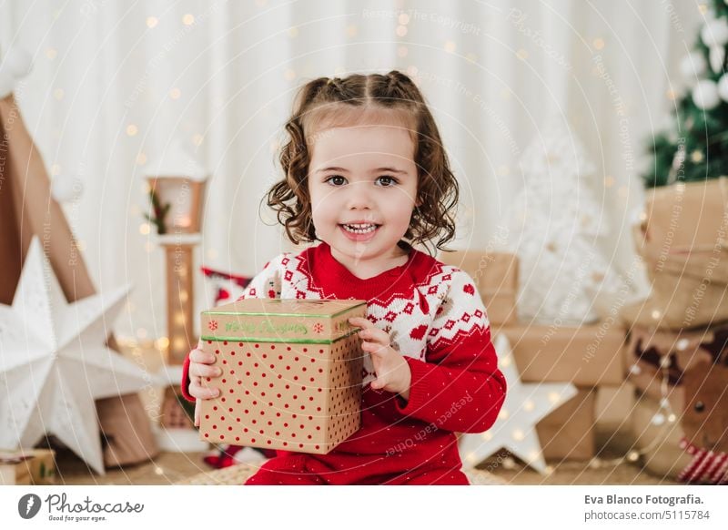 lächelnd niedlichen kleinen Mädchen zu Hause während der Weihnachtszeit hält Geschenk-Box Kind Weihnachten heimwärts Geschenke Glück heiter 2 Kinder Familie