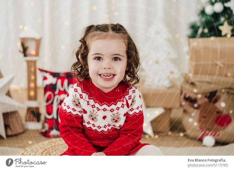 Lächelndes süßes kleines Mädchen zu Hause in der Weihnachtszeit Kind Weihnachten heimwärts Geschenke Glück heiter niedlich 2 Kinder Familie Dezember